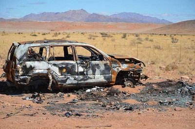ausgebranntes Schrottauto in der afrikanischen Wüste